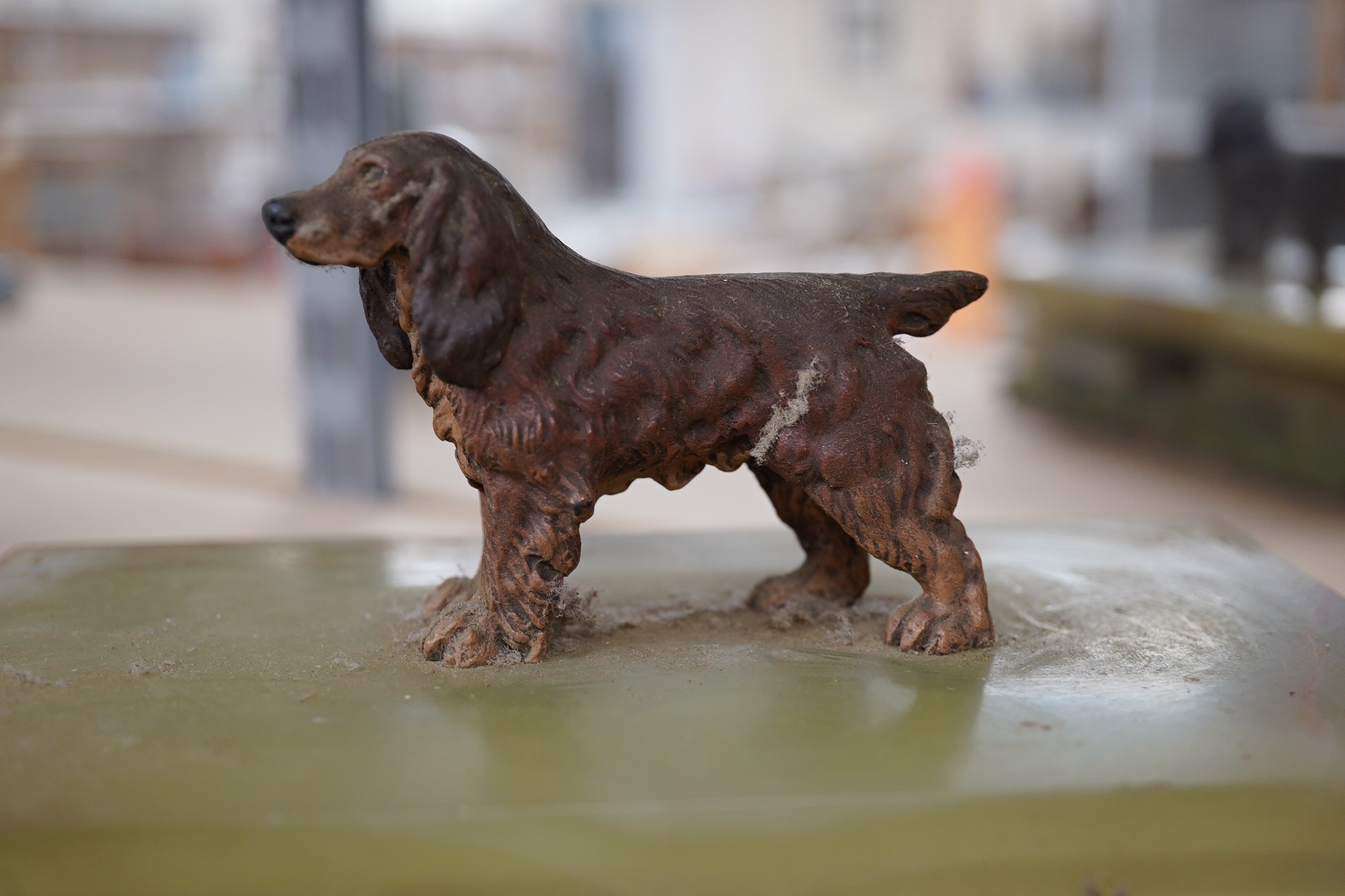 An Art Deco green onyx box, the lid surmounted with a cold painted bronze spaniel, flat packed joints need reglueing,16.5cm wide